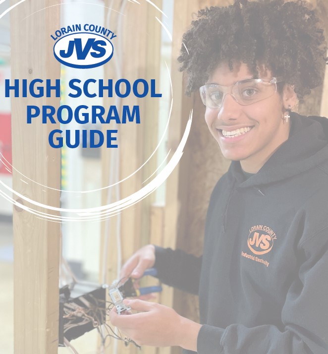 Male electrical student works in lab and smiles at camera